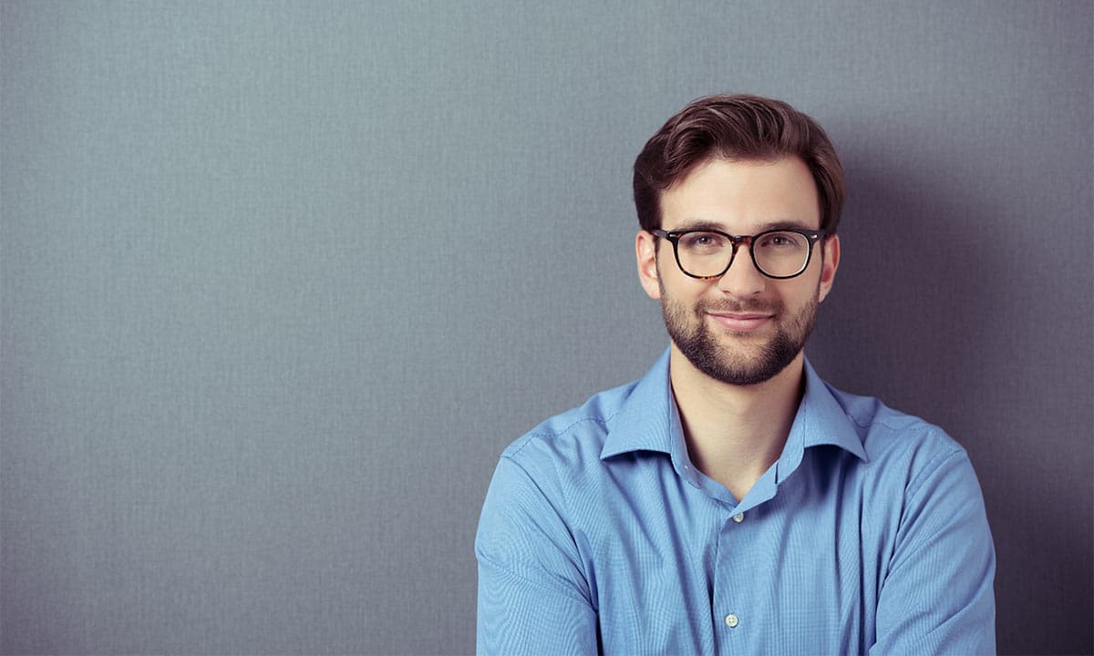 A man in a blue shirt wearing reglazed glasses