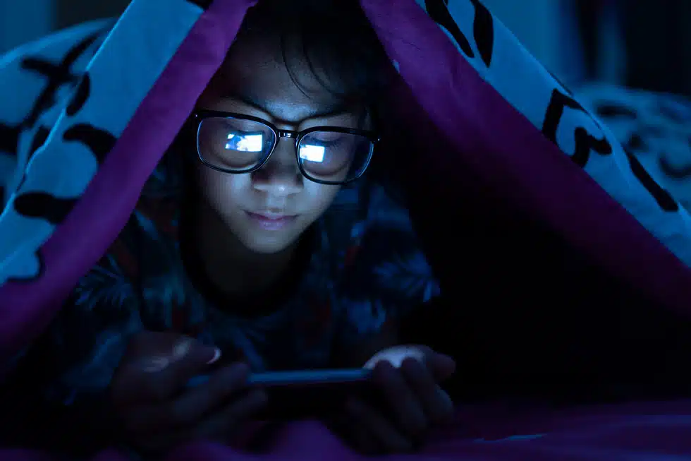 kids blue light glasses at night with mobile phone
