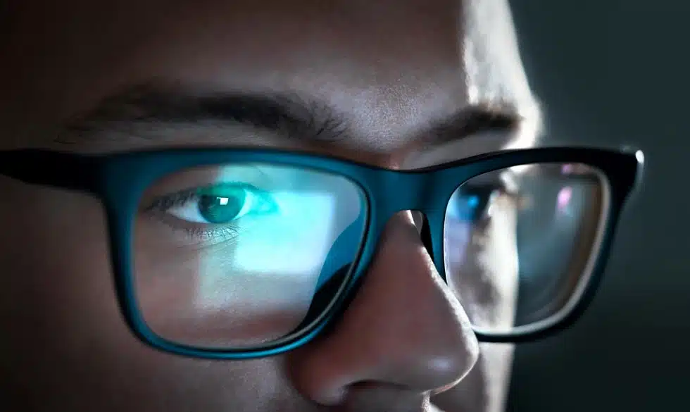 man at a computer wearing blue light blocking glasses