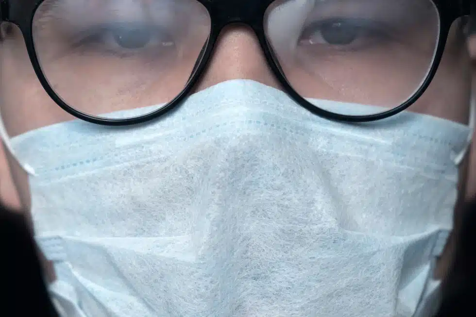 woman wearing face mask and steamed up foggy glasses