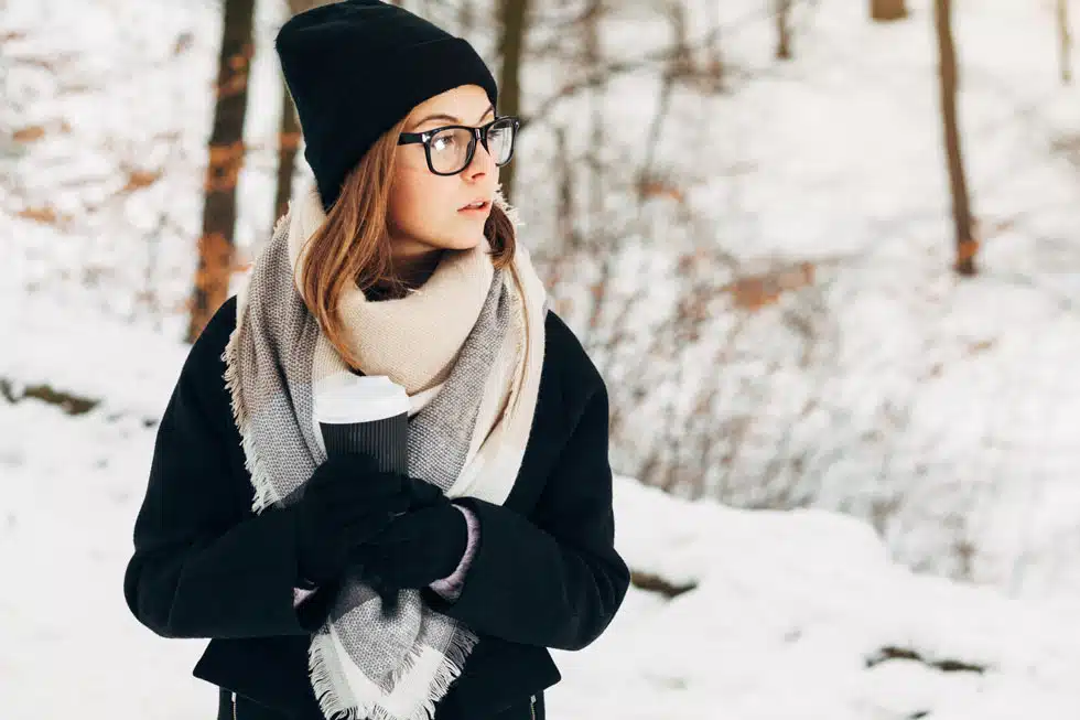 woman out in the snow with glasses providing cold weather eyecare