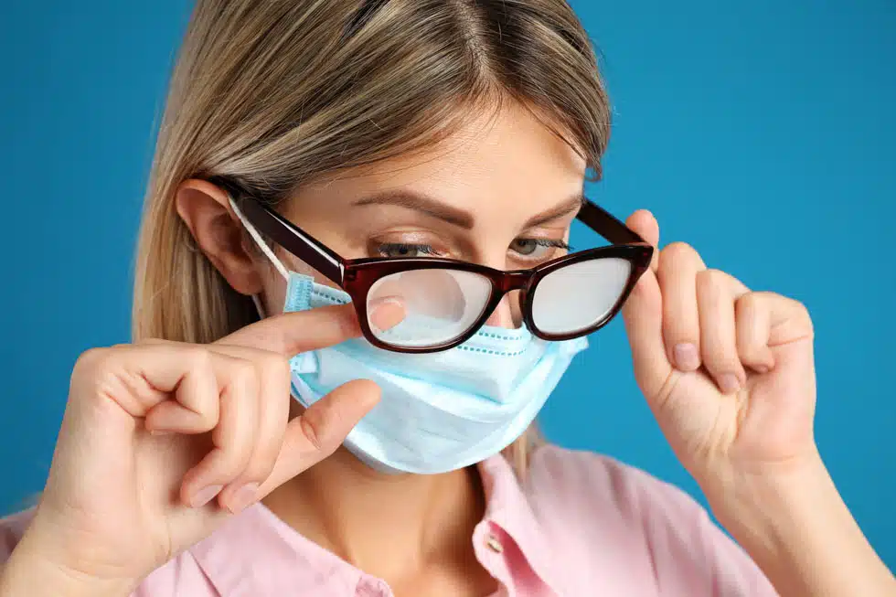 woman wearing face mask and steamed up foggy glasses