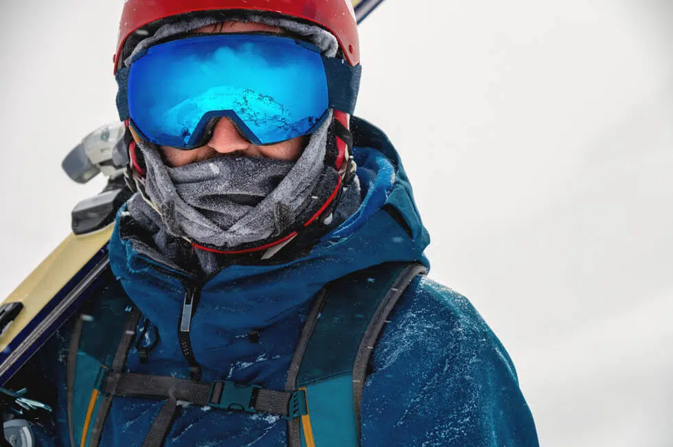 a person wearing prescription ski goggles, holding a ski