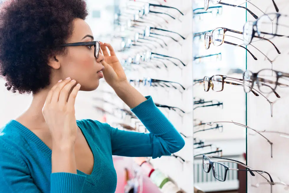 a person reviewing their reading glasses strength in a mirror