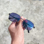 Picture of a reactolite sunglasses lens during the day under the hot sun held by hand
