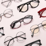 Flat lay of many different stylish glasses on light pink background