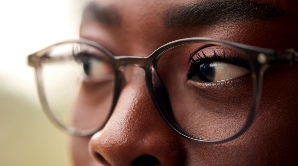 Close Up Portrait Showing Face Of Young Woman Wearing Glasses