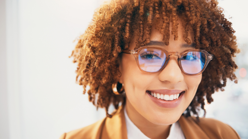 Portrait of woman smiling wearing blue light glasses