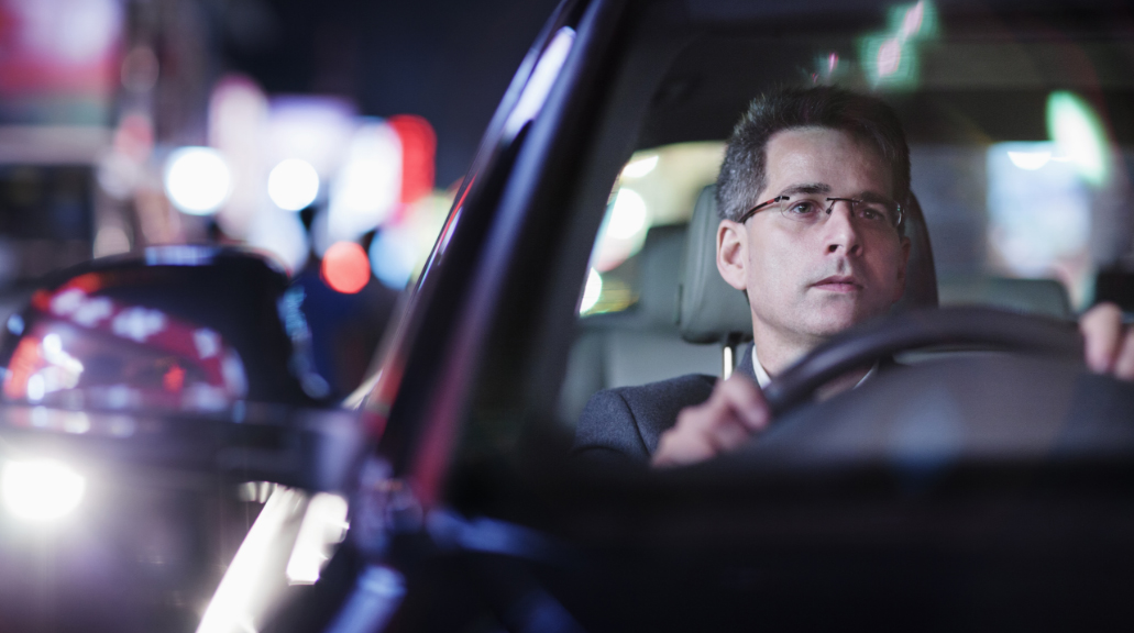 Businessman driving at night in the city