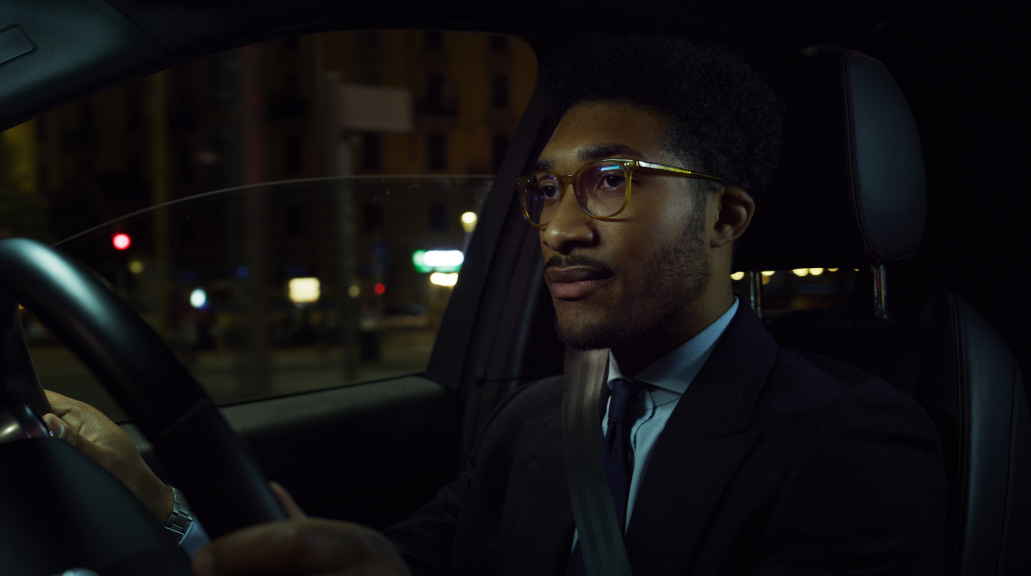 Man wearing glasses driving at night time