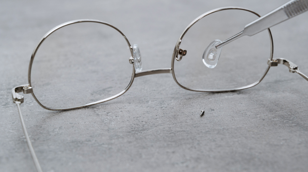 Closeup of professional installing new nose pads in glasses