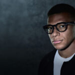Man wearing Oakley Meta glasses against dark background