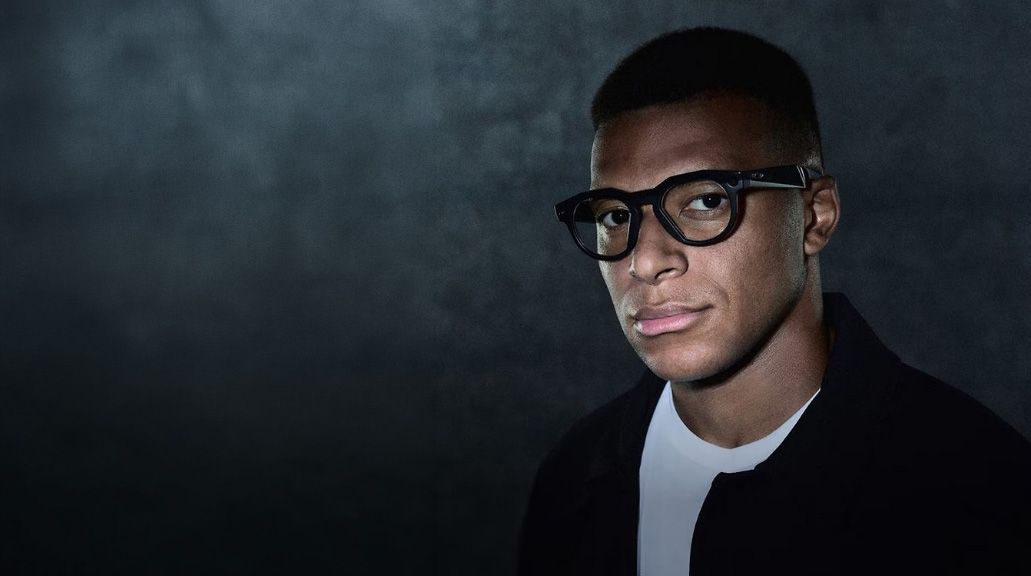 Man wearing Oakley Meta glasses against dark background