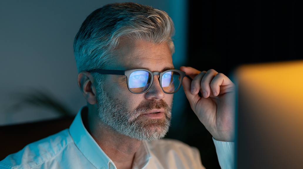 Focused Mature Man Wearing Glasses Working On Computer At Night
