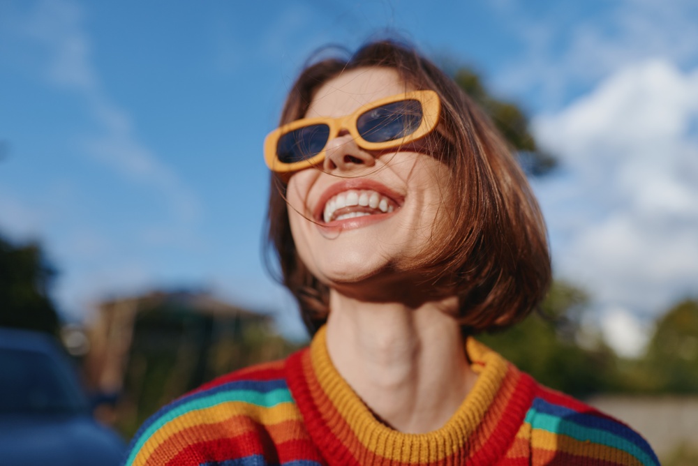 Stylish smiling women relaxing having fun at the beach wearing sunglasses, using smartphone to take selfie picture