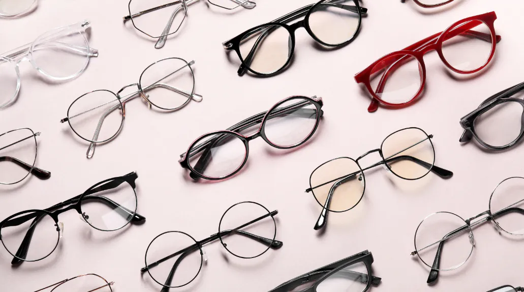 Flat lay of many different stylish glasses on light pink background