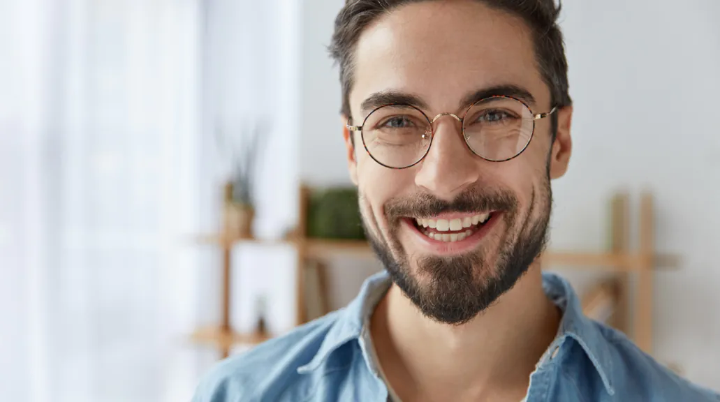 Close up shot of cheerful male wearing round spectacles